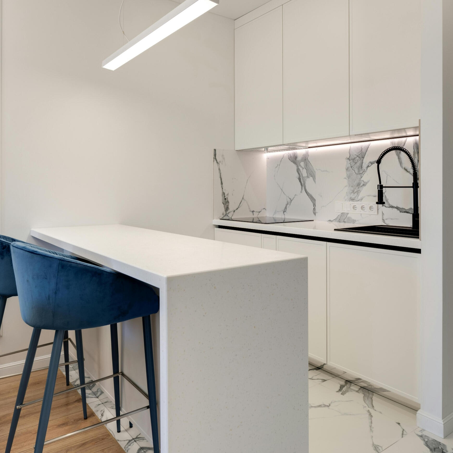 Modern kitchen with stainless steel double‑door fridge, white cabinetry, marble benchtop, and gas stove A bright modern kitchen featuring a stainless steel double‑door fridge, white cabinetry with silver handles, a marble benchtop, and a gas stove. This clean, practical layout showcases the quality renovation work provided by Sydney Budget Kitchens.