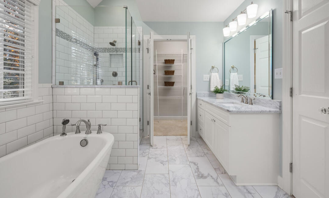 Contemporary bathroom remodel in Sydney with a freestanding bathtub, glass shower enclosure, marble-look flooring, subway tiles, and custom bathroom renovation services.